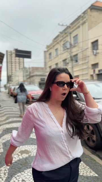 Cliente de óculos escuros caminhando no calçadão do Centro